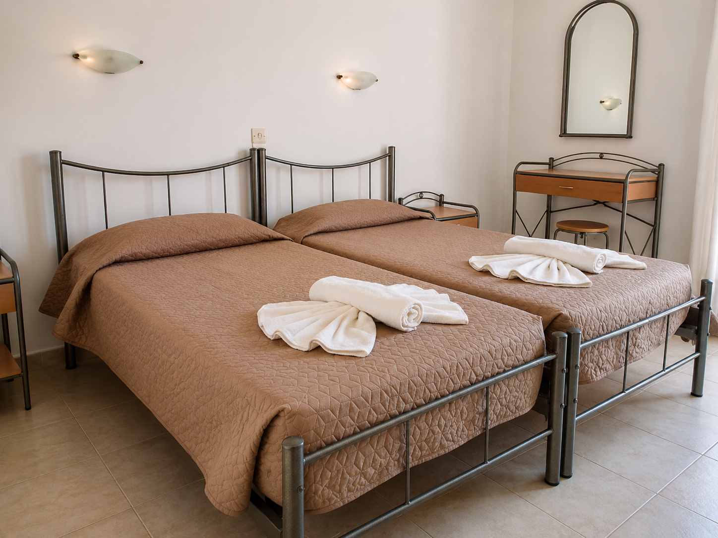 Light-filled Monika Hotel guest room with white linens and open balcony doors revealing a view of the Ionian sea
